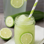 Hausgemachter Gurken-Limetten-Slush in einem Glas mit Limettenscheiben – erfrischendes Sommergetränk aus Gurke, Limette und Eis